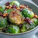 Freshly baked Roasted Brussels Sprouts Bowl topped with toasted walnuts, dried cranberries, and pumpkin seeds for a wholesome dinner.