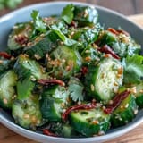 A crunchy Asian-inspired salad with fresh cucumbers, spicy chili oil, and tangy rice vinegar, ideal as a side dish.  