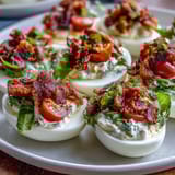 Creamy BLT Deviled Eggs topped with bacon, tomatoes, and lettuce bring classic sandwich flavors to every bite.  