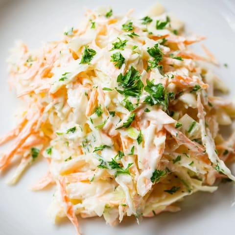 Freshly grated apple adds sweet crunch to a creamy bowl of Coleslaw with Apple, served chilled as a crisp side dish.