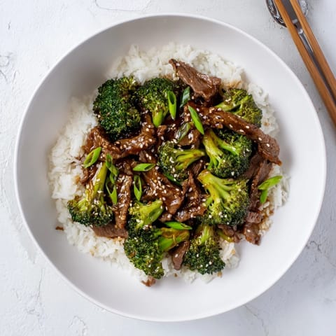 A close-up view of tender beef strips and crisp broccoli florets coated in a rich, savory stir-fry sauce.