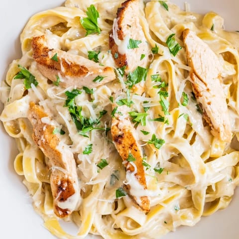 Golden-brown Cajun chicken sliced over fettuccine in a velvety Alfredo sauce, topped with parsley.