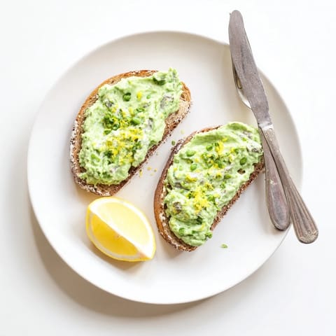 Creamy whipped ricotta and sweet peas blended with mint on toasted sourdough, a perfect vegetarian breakfast or light lunch, finished with lemon zest.