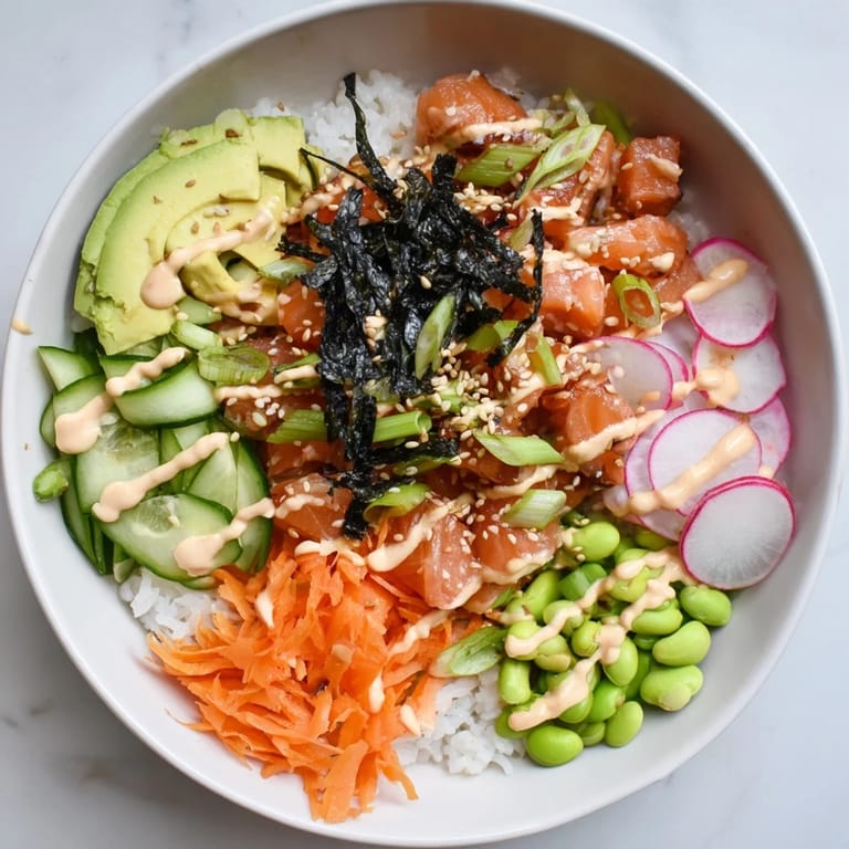 Close-up of a colorful Poke Bowl with pickled ginger, nori strips, and julienned carrots, perfect for a light lunch.
