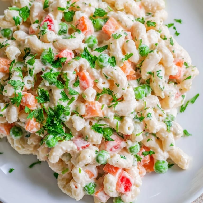 Classic American Macaroni Salad tossed with red onion and carrots in a creamy mayonnaise dressing, perfect for gatherings.
